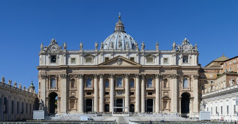 A large building with a dome and statues Petersplatz Vatikan
