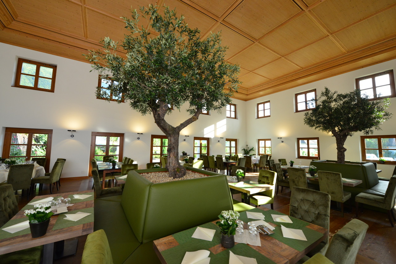 Innenansicht des Restaurant Torkel mit dem markanten gestuften Baum und elegantem Ambiente.